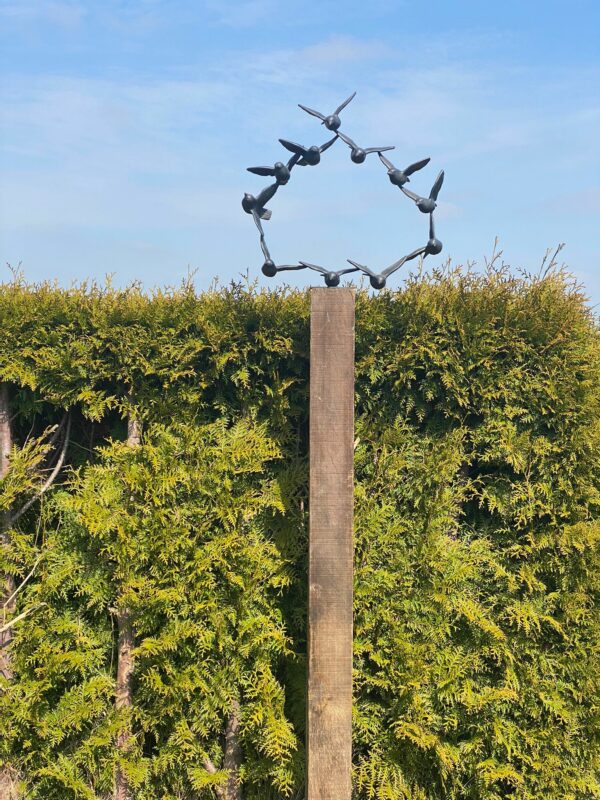 Vogelschwarm Skulptur im Garten auf Holzpfeiler